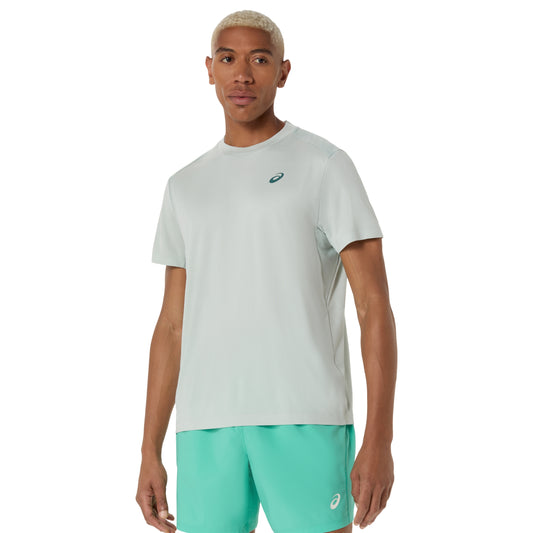Man wearing a cold moss Asics t-shirt and teal shorts with a brand logo on a white background