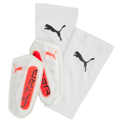 Pair of white shin guards with red 'ULTRA FLEX' branding and Puma logo on a white background