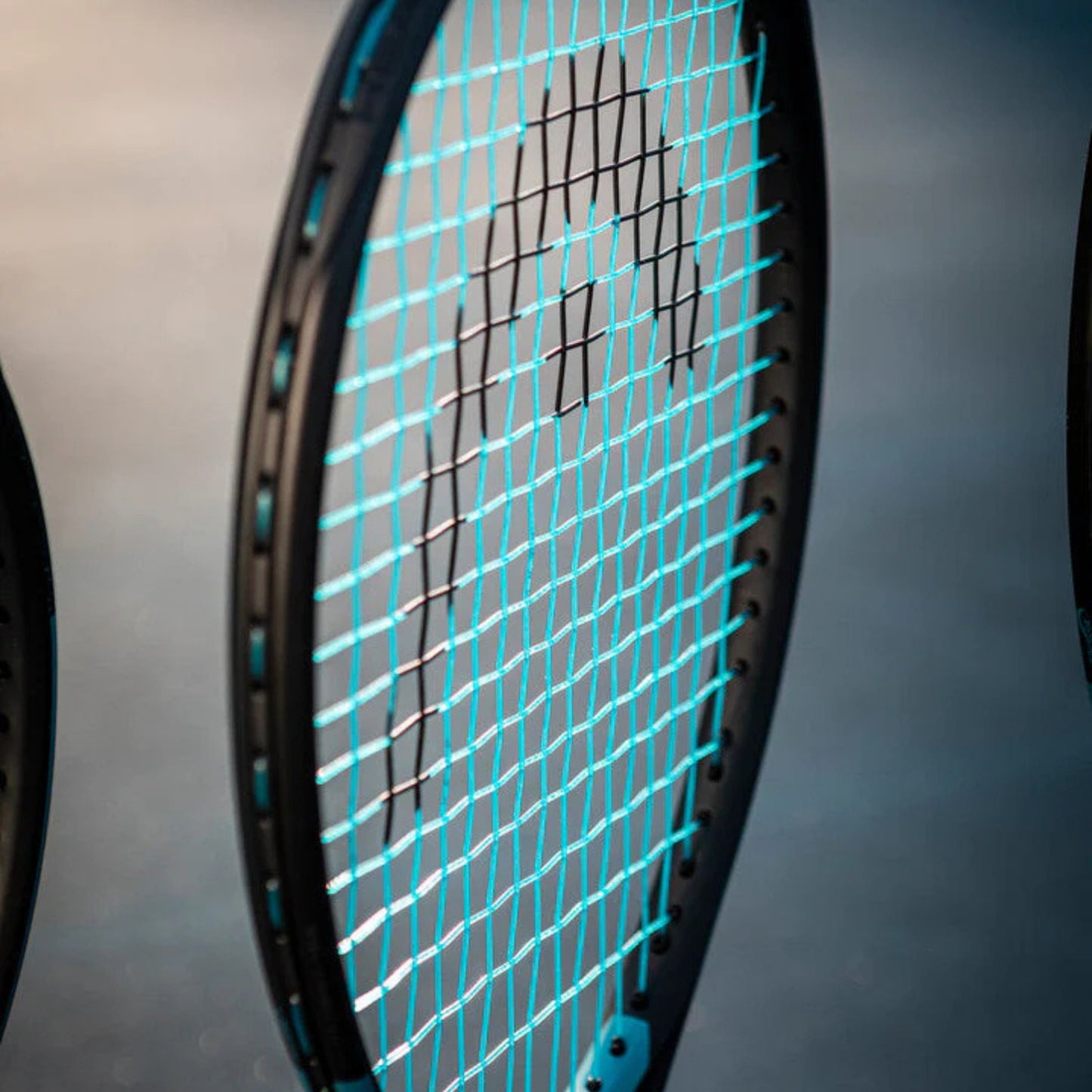 Close-up of a tennis racket with a blurred background