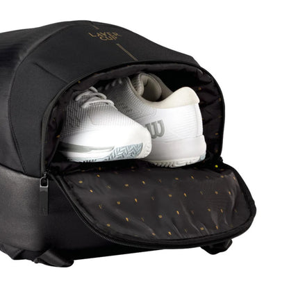 Black backpack with white tennis shoes inside, featuring a brand logo on the top.