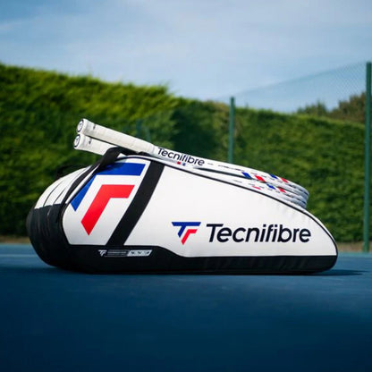 Tecnifibre tennis racket bag on a tennis court with a clear blue sky.