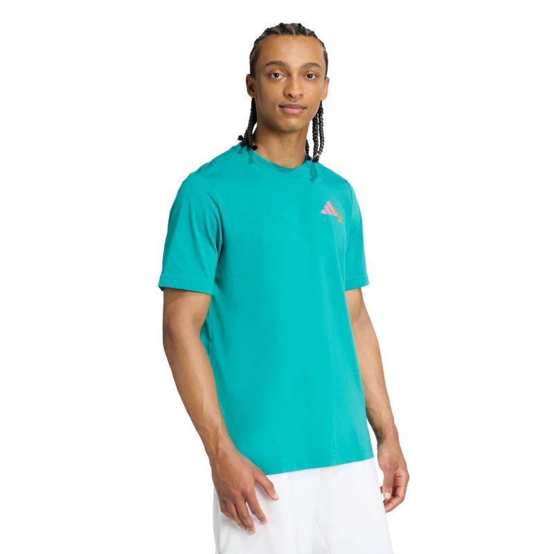 Person wearing a teal Adidas shirt with a logo on a white background